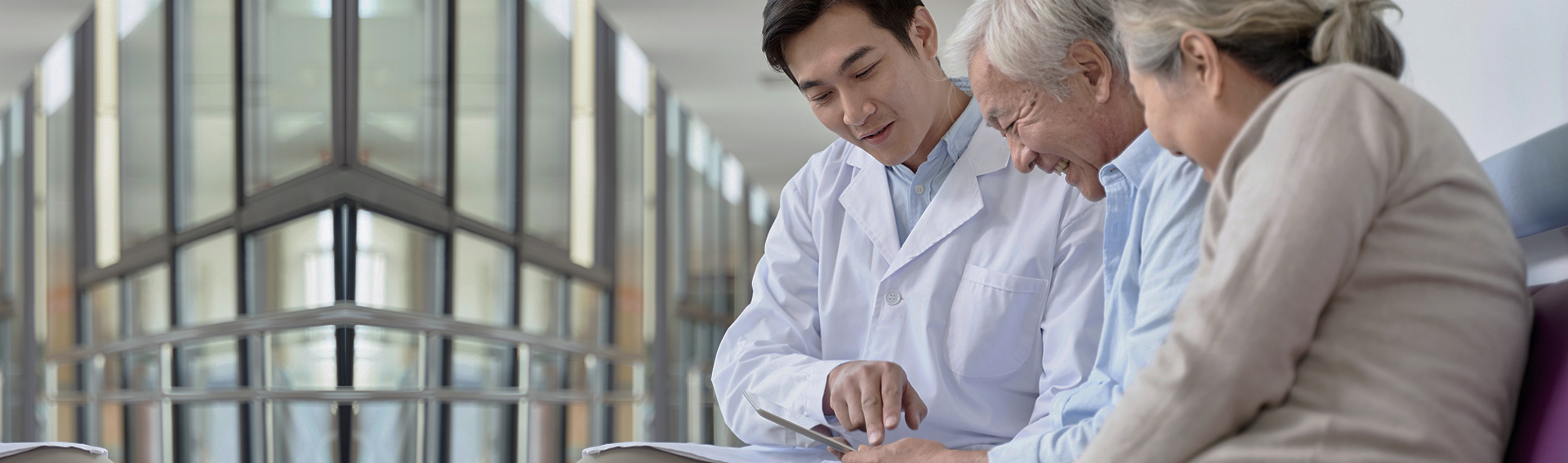 年輕男子向長輩說明文件，長輩面帶微笑