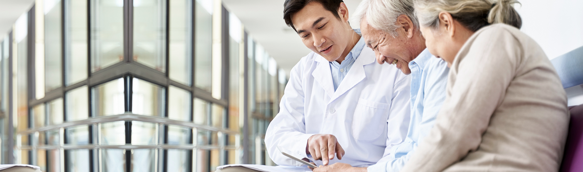 年輕男子向長輩說明文件，長輩面帶微笑